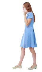 side view of a woman walking with a mobile phone. beautiful girl in motion.  backside view of person.  Rear view people collection. Isolated over white background.  Skinny girl in blue dress talking