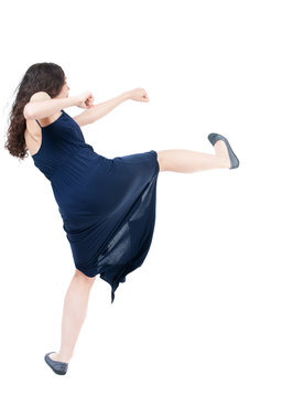 skinny woman funny fights waving his arms and legs. Isolated over white background. The dark curly girl in blue evening dress waving his arms and legs.