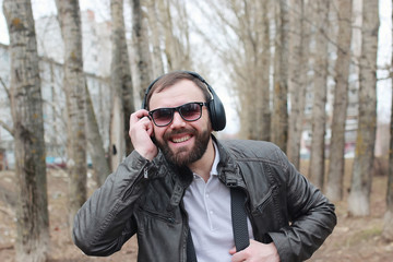 man with beard and headphones in the park