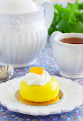 Cakes with mango and passion fruit with cream in the mirror glaze. Selective focus.