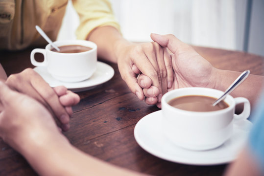 Hands of couple having date in cafe