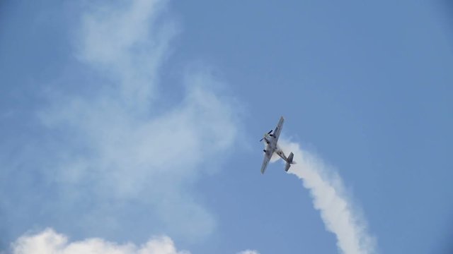 An old historical military soviet russia plane flying and performs aerobatics - full stall turns, slow motion