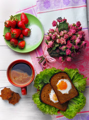 Cup of coffe and two fried eggs in toast on the salad  stars