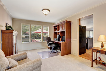 Cozy home office with wooden furniture and carpet floor.