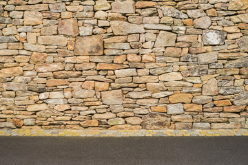 Hintergrund Natursteinmauer gepflasterte Entwässerungsrinne und Straße aus Asphalt - Background stone wall paved gutter and road made of asphalt