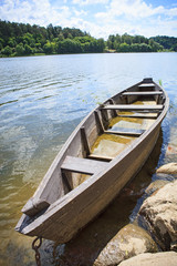 Obraz premium Wooden rowing boat on lake shore