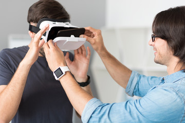 Pleasant cheerful colleagues testing virtual reality glasses