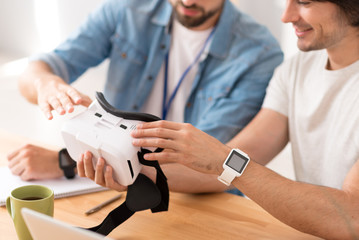 Pleasant colleagues working on virtual reality glasses