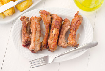 overhead take fried pork ribs in white tray on wooden