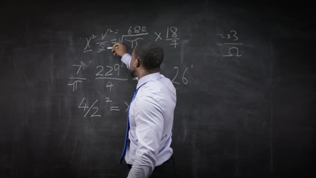  Portrait of man in a white coat, standing in front of blank blackboard 