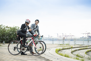 Obraz premium Businessmen are searching in the smartphone riding a bicycle