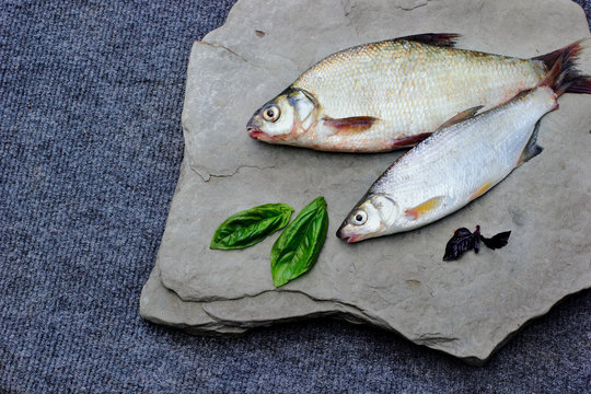 Freshly caught bream and roach.On stone plate decorated with bas