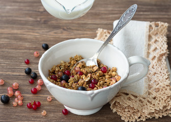 Homemade delicious healthy granola with nuts, seeds, honey and fresh berries in a ceramic cup