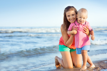 woman with a child playing on the beach