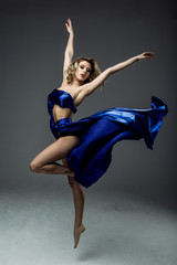 Beautiful young woman dancer in blue top, long blue skirt dancing.  