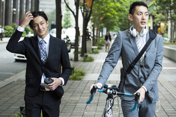 Businessman is walking while talking down the bicycle