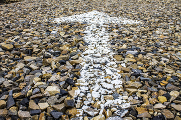 Arrow painted on the parking lot on the rocks © Heroc