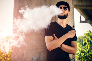 Vaper with beard in sunglasses vaping outdoor