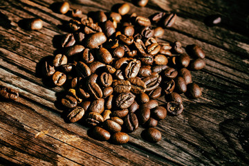 Coffee Beans on old wooden table. The effect of film grain.