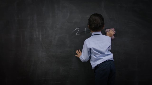  Portrait of thinking woman sitting in front of blackboard with math formulas