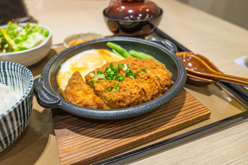 Chicken Fried egg in black dish on wood table