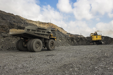 Excavator and truck in the iron quarry