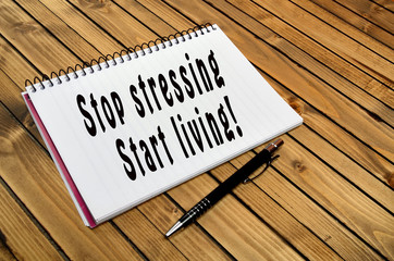The words Stop stressing Start living on notebook