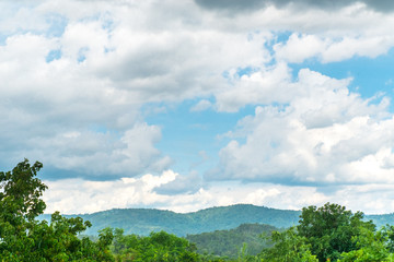 Landscape view of raining at forest and blue sky and cloud with mountain at background