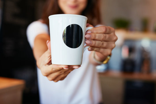 Closeup of waitress giving coffee in the mug