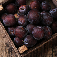 ripe plums on wooden vintage background