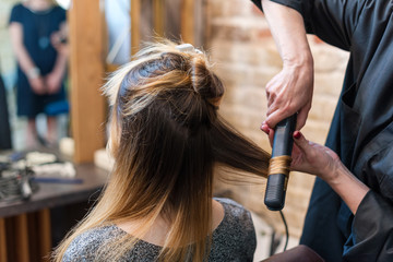professional hairdresser using curling iron hair curls