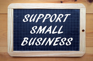 The phrase Support Small Business in white text on a blackboard as a reminder