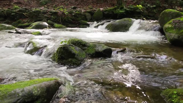 small cascades of the brook among huge boulders covered with moss. beautiful nature scenery