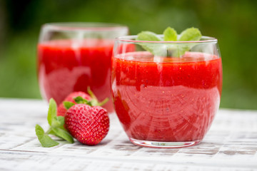 strawberry smoothie on a light wooden background