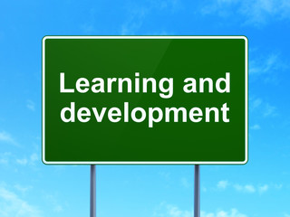 Studying concept: Learning And Development on road sign background