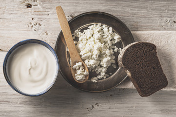 Fresh cottage cheese on the  metal plate  with bread on the white wooden table top view