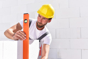 Bauarbeiter/ Maurer beim Hausbau - Kontrolle mit einer Wasserwaage // Construction workers building...