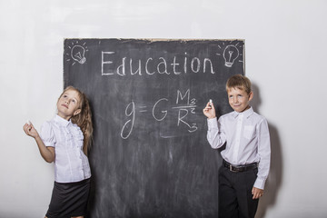 Boy and girl of elementary school in class background slate