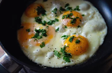 Classically fried eggs on a pan seasoned with parsley. Delicious fresh breakfast idea.