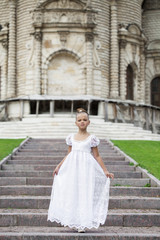 Fototapeta premium Portrait of a beautiful young little girl in white gown