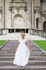 Fototapeta premium Portrait of a beautiful young little girl in white gown