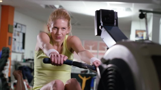  Woman working out on rowing machine at the gym