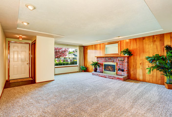 Empty living  room with wood panel wall and fireplace