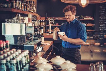 Barista tasting a new type of coffee in his coffee shop.
