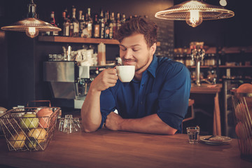 Barista tasting a new type of coffee in his coffee shop.