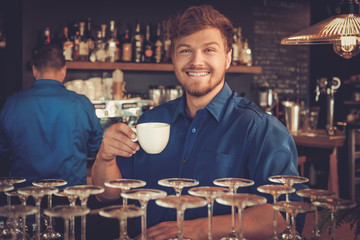 Barista tasting a new type of coffee in his coffee shop.