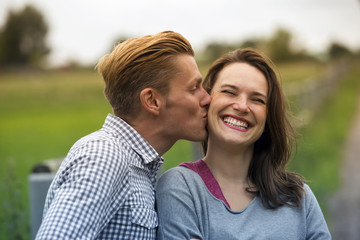 Obraz premium man kissing woman on her cheek