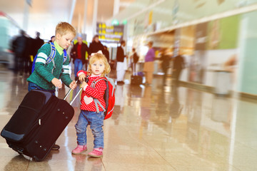little boy and girl with luggage travel in airport