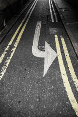 Left turn arrow painted on an asphalt street