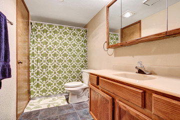 Fototapeta na wymiar Bathroom interior with vanity, tile floor and green shower curtain.
